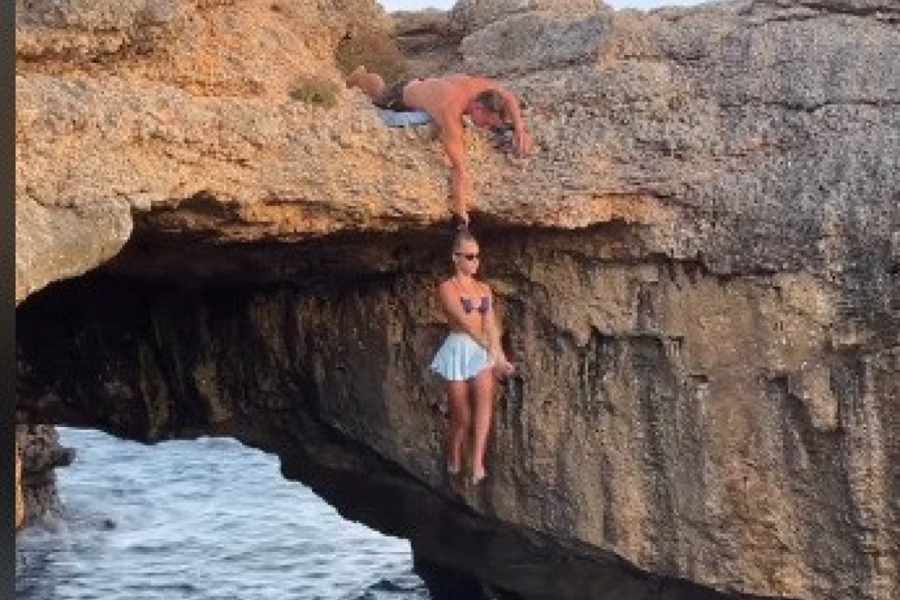 DRŽAO JU JE MOMAK ZA KOSU DOK JE VISILA IZNAD VODE: Zbog onoga što je devojka radila svima je zastao dah, a samo trenutak kasnije je poletela sa grebena (VIDEO)