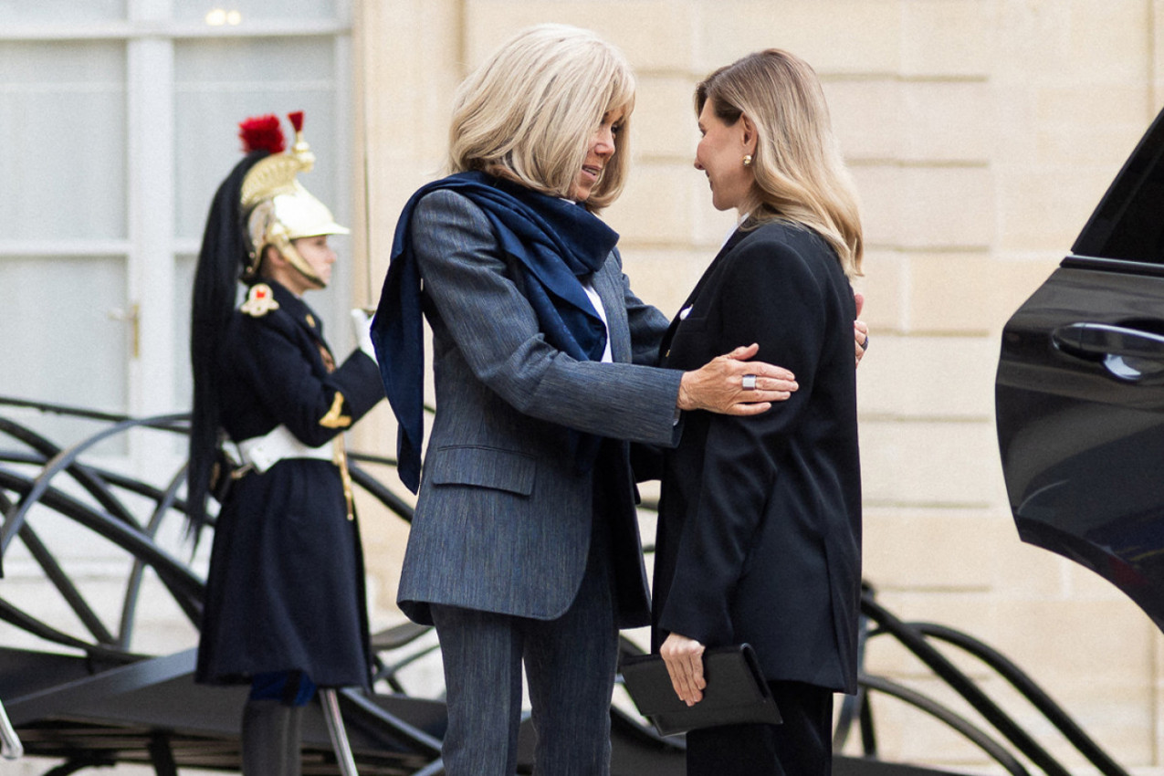 Brižit Makron u igla štiklama, evidentno mršava dok se srdačno pozdravlja sa modnom suparnicom - dve prve dame i dva stila